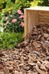 Bark chips on green grass in garden, closeup