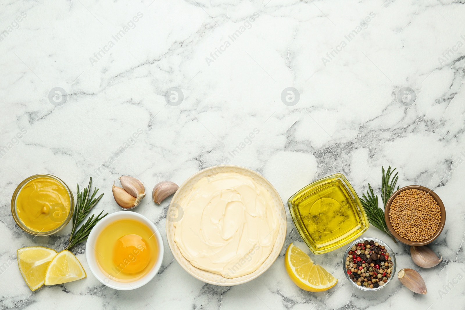 Photo of Bowl with fresh mayonnaise and ingredients on white marble table, flat lay. Space for text