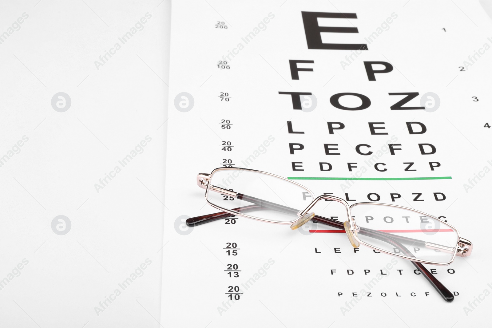 Photo of Glasses and vision test chart isolated on white