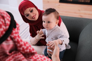 Happy Muslim family with little son in living room