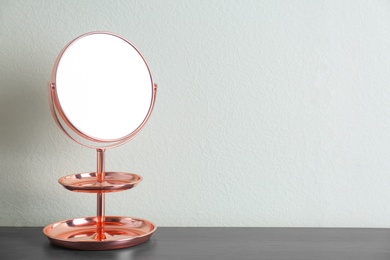 Photo of Mirror with accessory holder on table near light wall