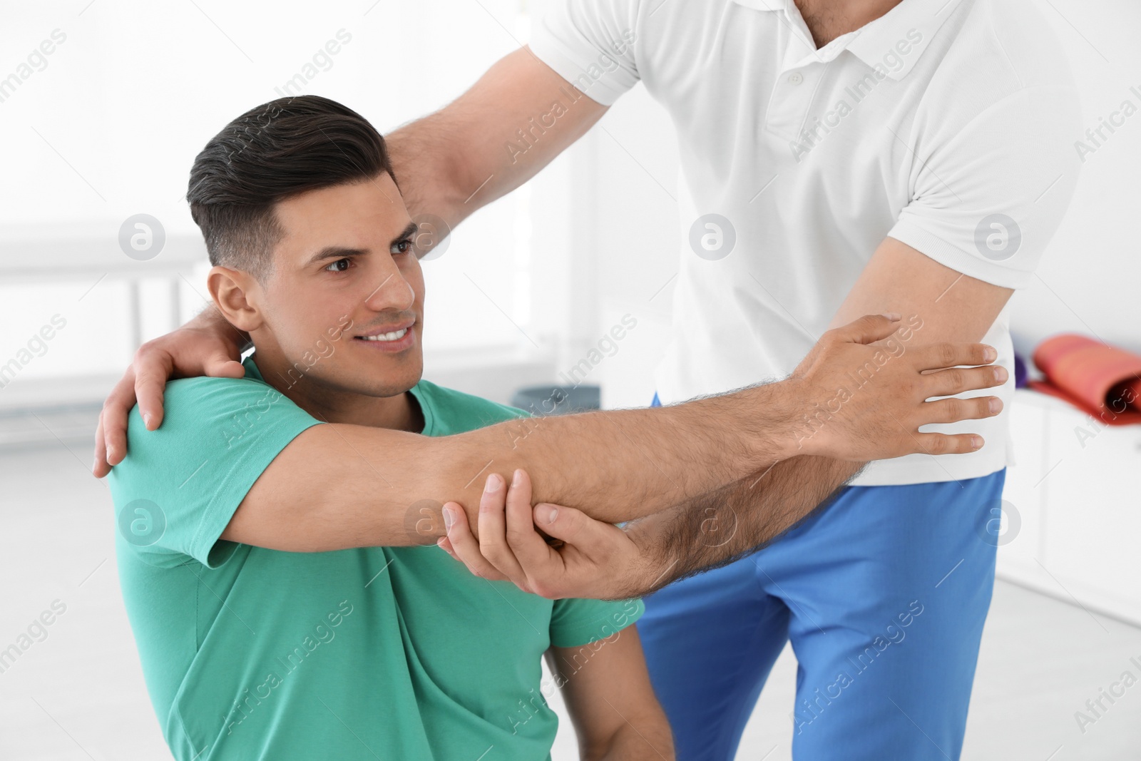 Photo of Professional physiotherapist working with male patient in rehabilitation center