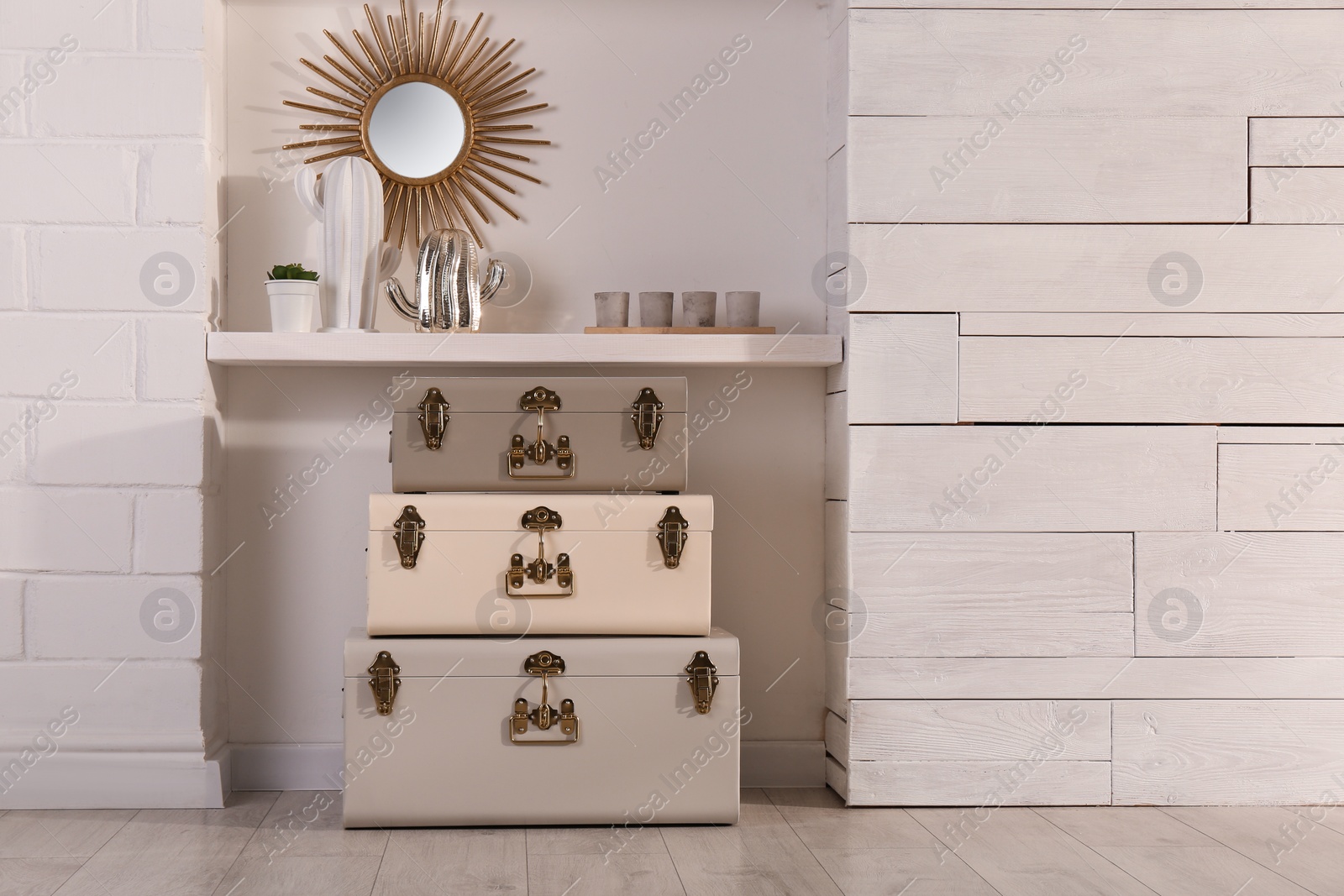 Photo of Stylish storage trunks and different decor elements near white wall indoors. Interior design