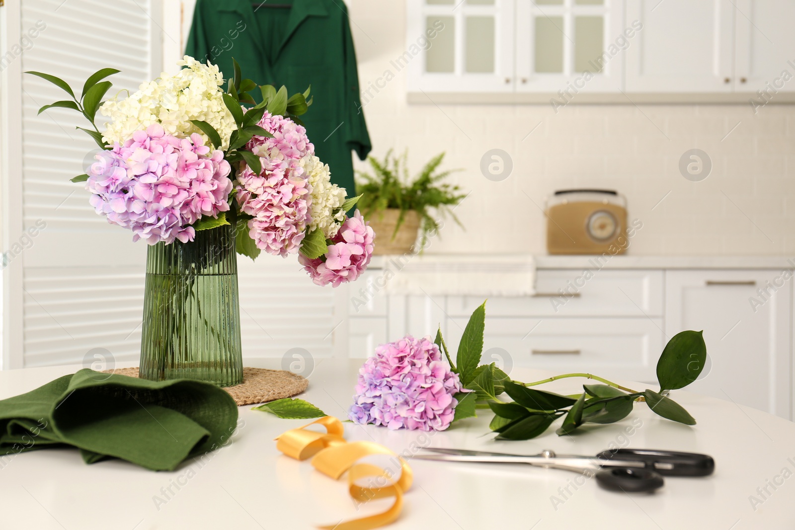 Photo of Bouquet of beautiful hydrangea flowers on white table indoors. Interior design