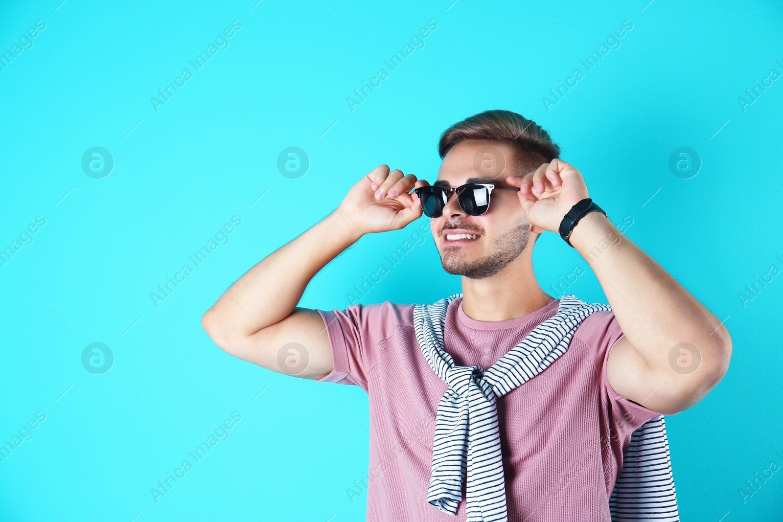 Photo of Young man with trendy hairstyle on color background