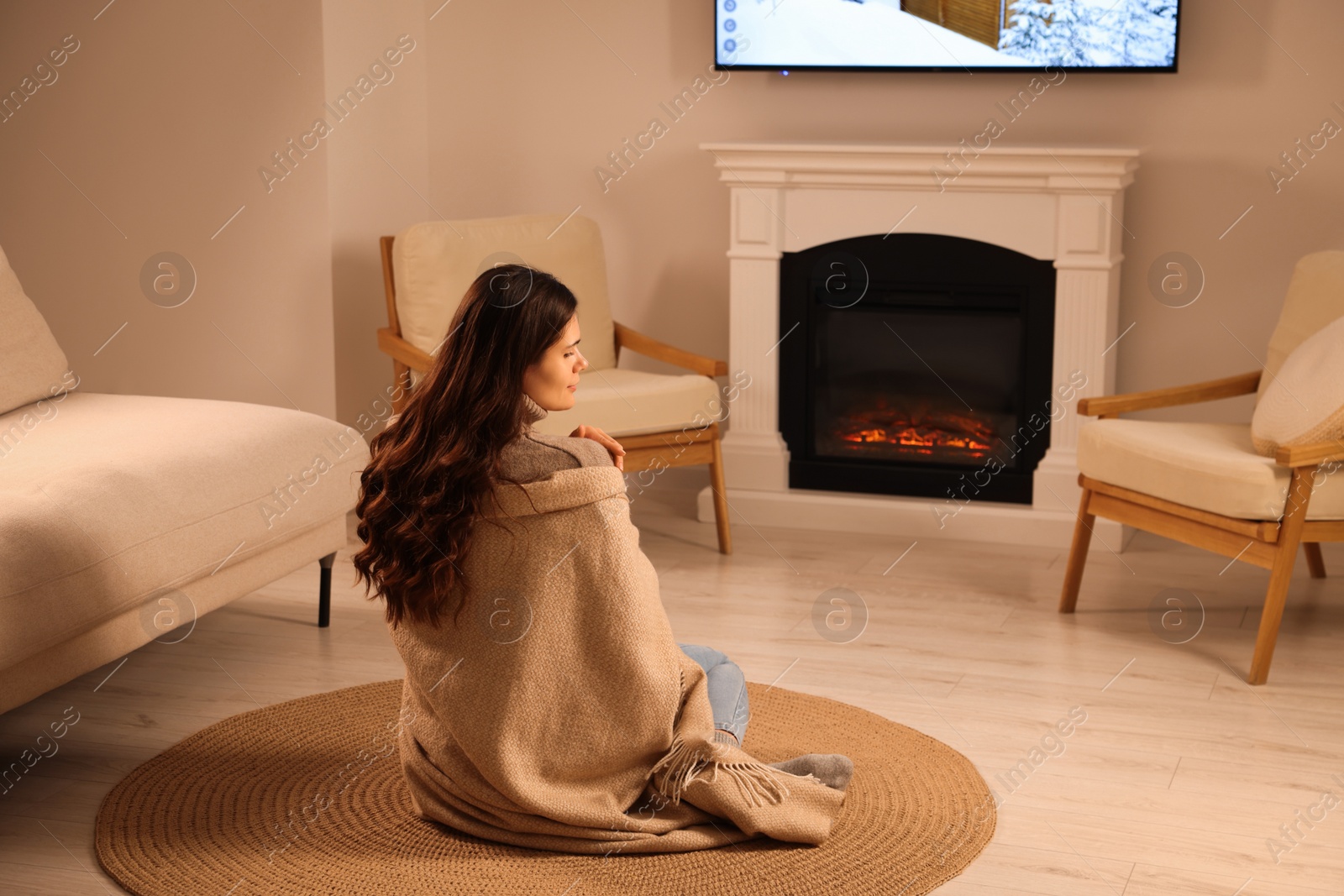 Photo of Young woman relaxing on floor near fireplace at home