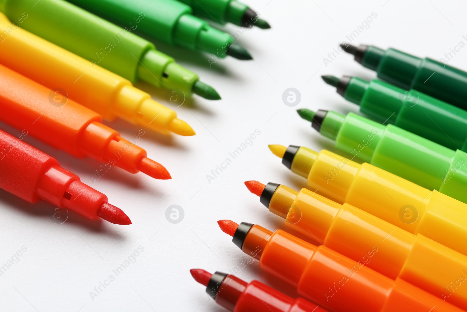 Photo of Composition with colorful markers on white background, closeup. Energy efficiency concept