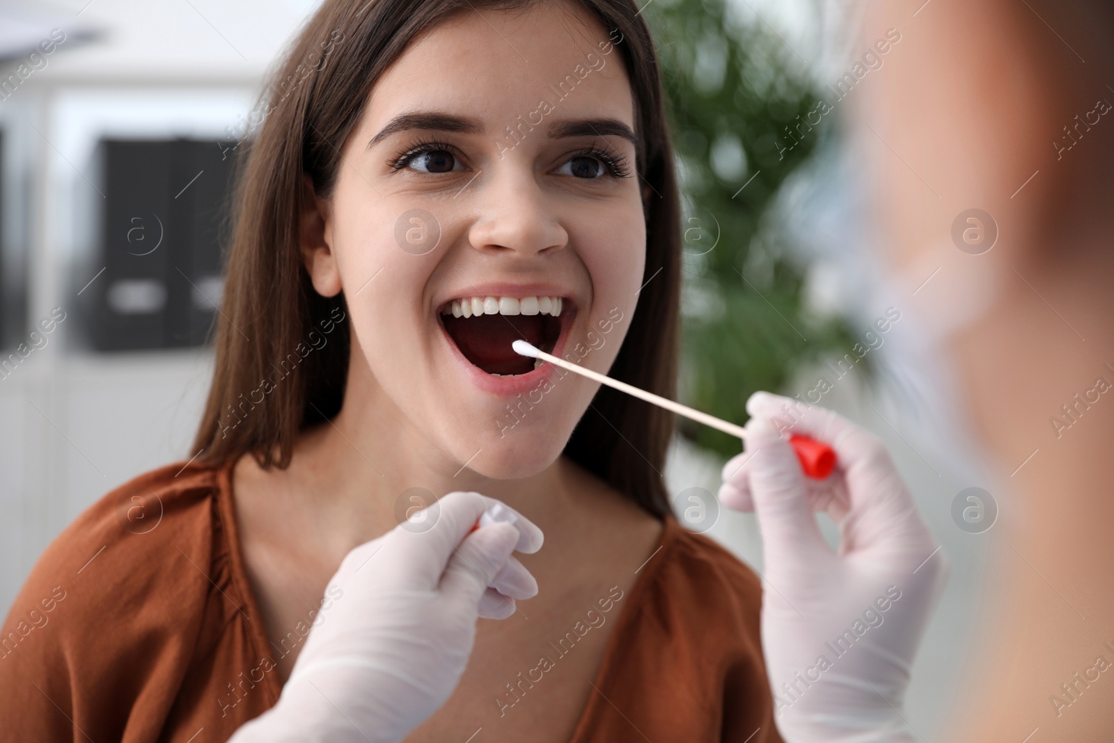 Photo of Doctor taking sample for DNA test from woman in clinic