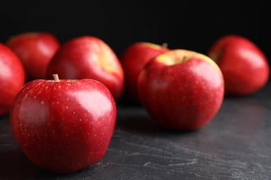 Fresh ripe red apples on black table, closeup