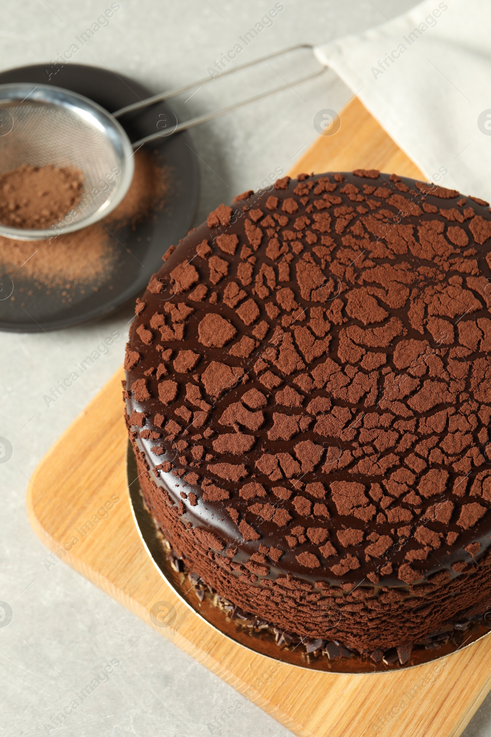 Photo of Delicious chocolate truffle cake and cocoa powder on light grey table, above view