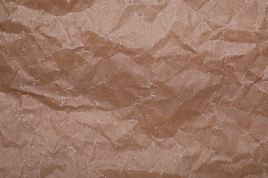 Photo of Texture of crumpled brown baking paper as background, top view