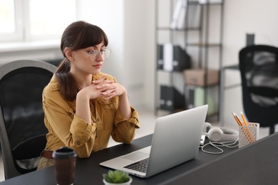 Photo of Woman watching webinar at table in office