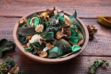 Photo of Aromatic potpourri of dried flowers in bowl on wooden table