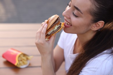 Lviv, Ukraine - September 26, 2023: Woman eating McDonald's burger outdoors, closeup