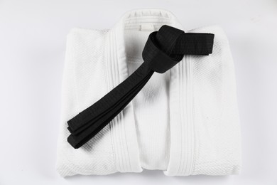 Photo of Black karate belt and kimono isolated on white