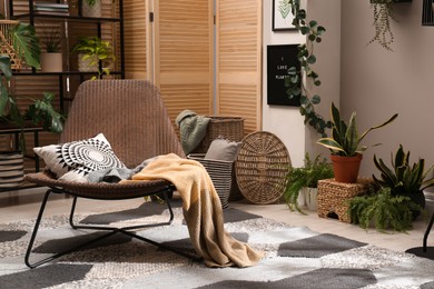 Lounge area interior with comfortable armchair and beautiful houseplants