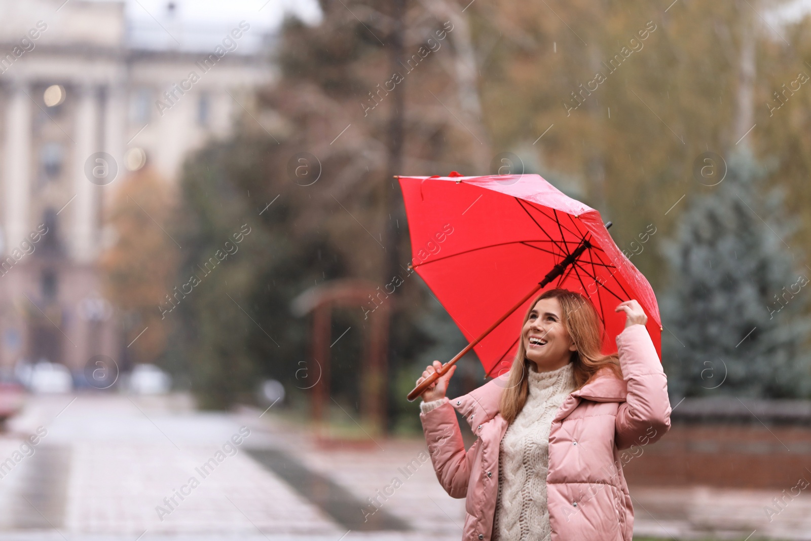 Photo of Woman with umbrella in city on autumn rainy day