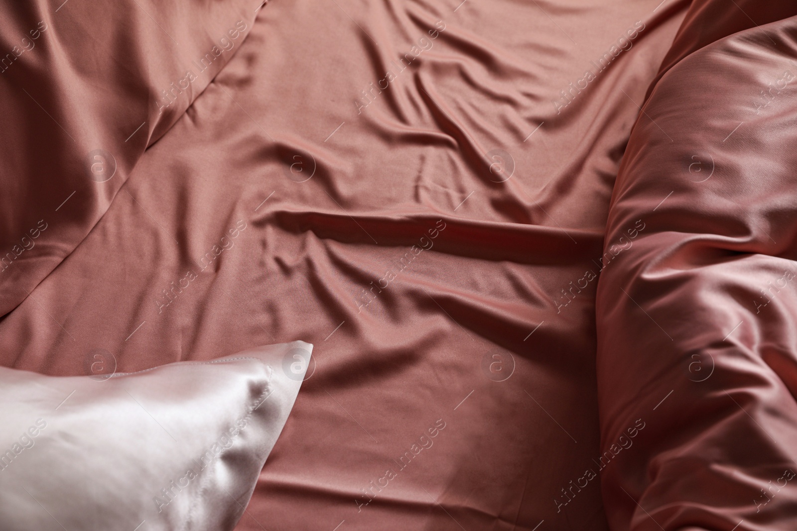 Photo of Closeup view of bed with beautiful silk linens