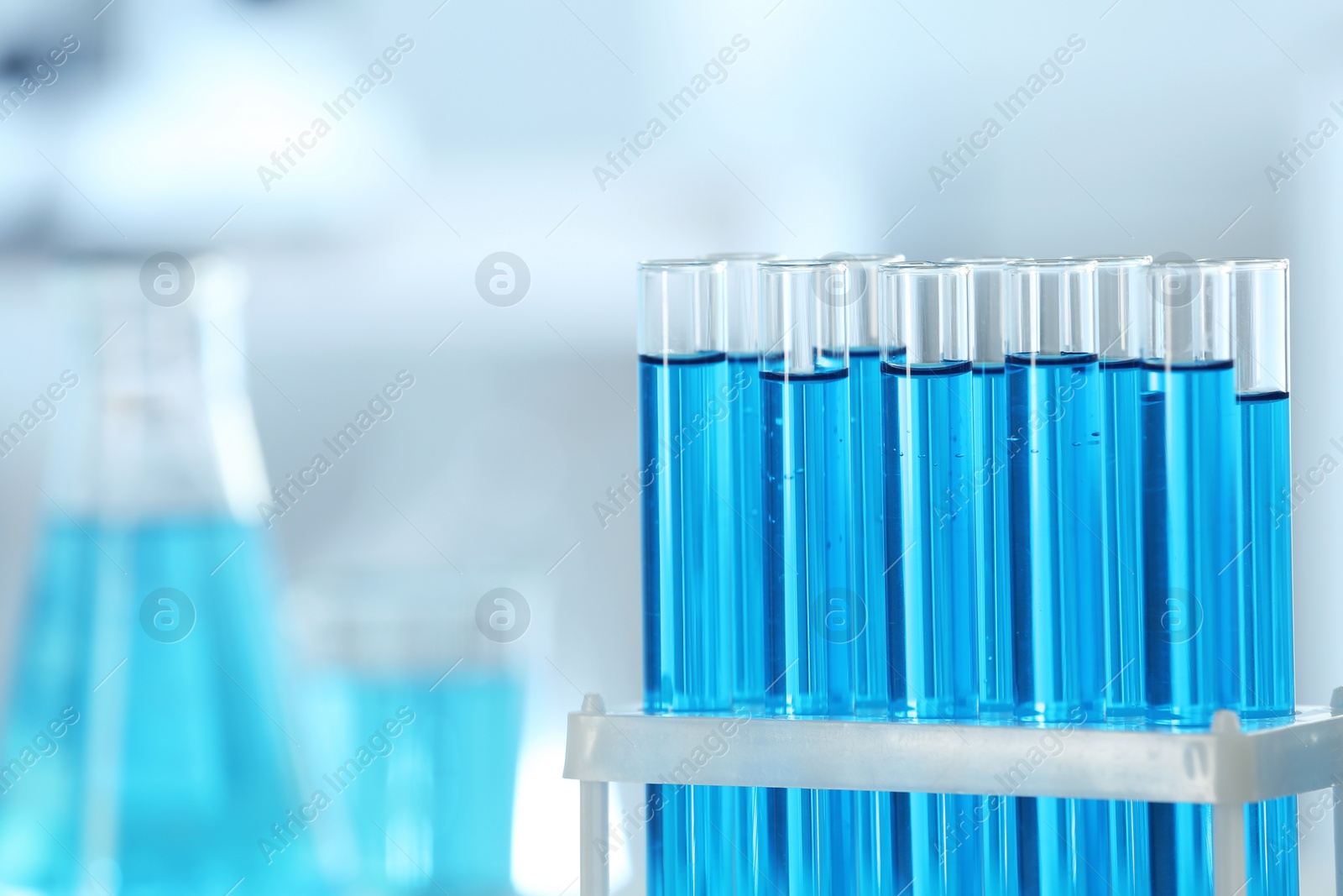 Photo of Test tubes with light blue liquid in laboratory, closeup