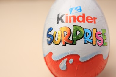 Photo of Slynchev Bryag, Bulgaria - May 25, 2023: Kinder Surprise Egg on beige background, closeup. Space for text