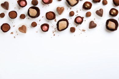 Photo of Different delicious chocolate candies on white background, flat lay. Space for text