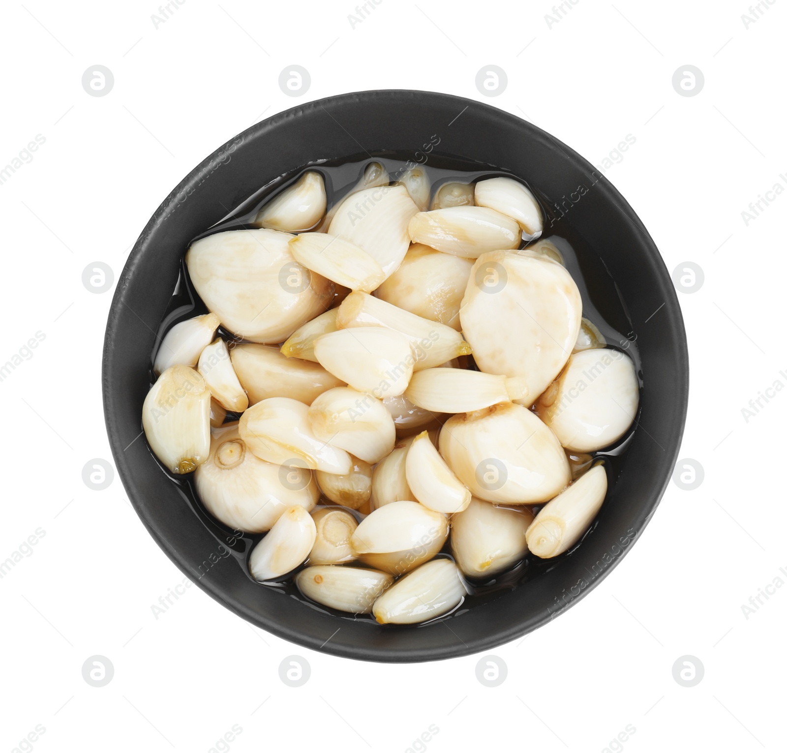 Photo of Peeled garlic cloves with honey in bowl isolated on white, top view