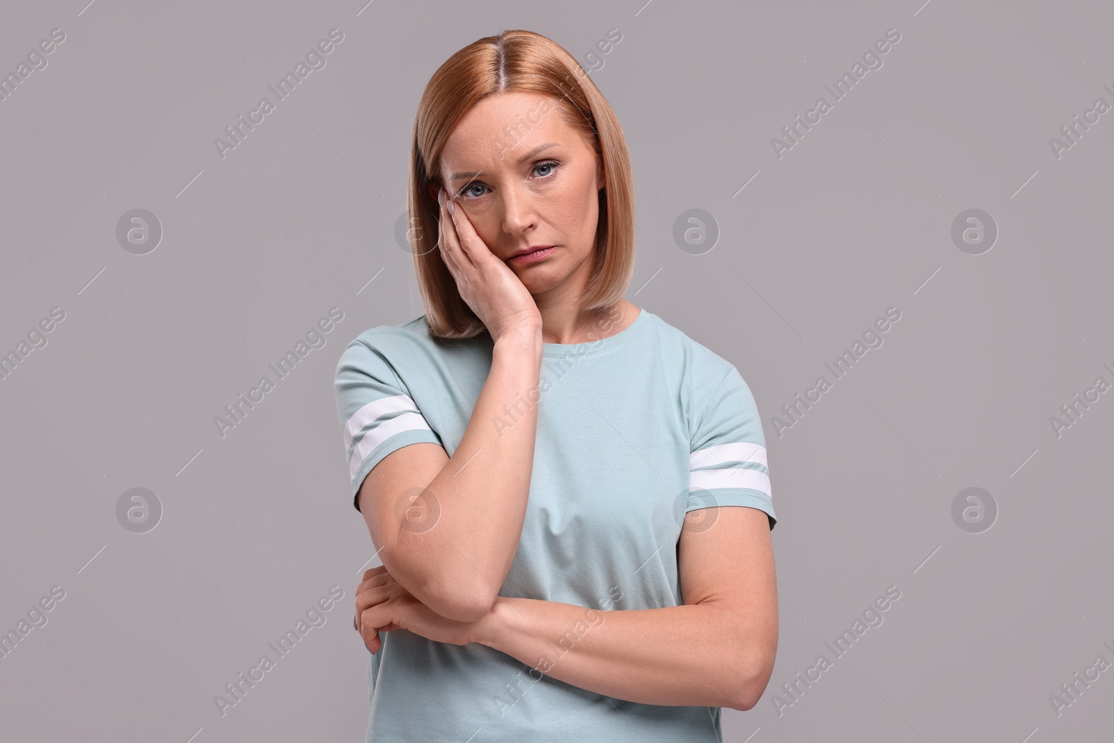 Photo of Portrait of sad woman on grey background