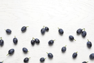 Photo of Fresh ripe juicy grapes on white wooden background, top view. Space for text