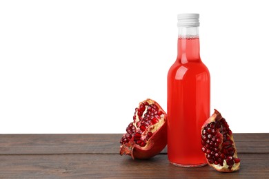 Delicious kombucha in glass bottle and pomegranate on wooden table against white background, space for text