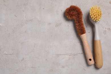 Photo of Cleaning brushes on light grey table, top view. Space for text