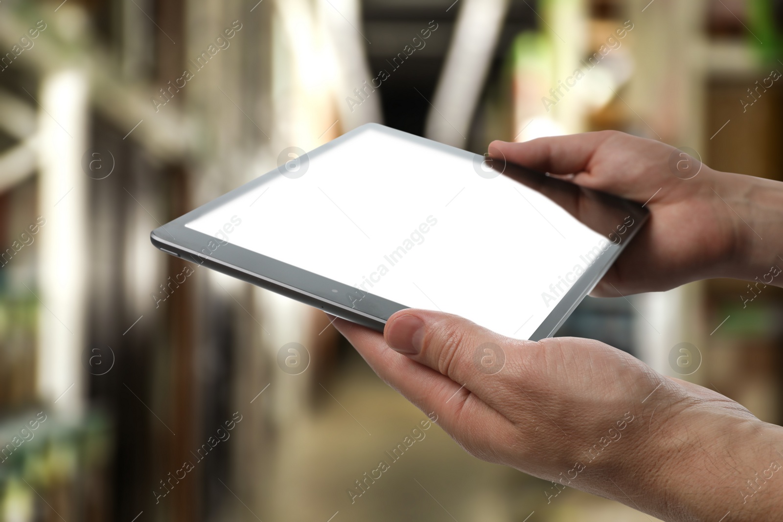 Image of Wholesale trading. Man using WMS app on tablet at warehouse, closeup 