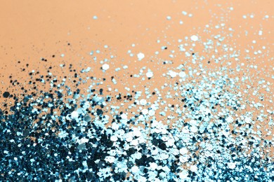 Photo of Shiny bright blue glitter on beige background