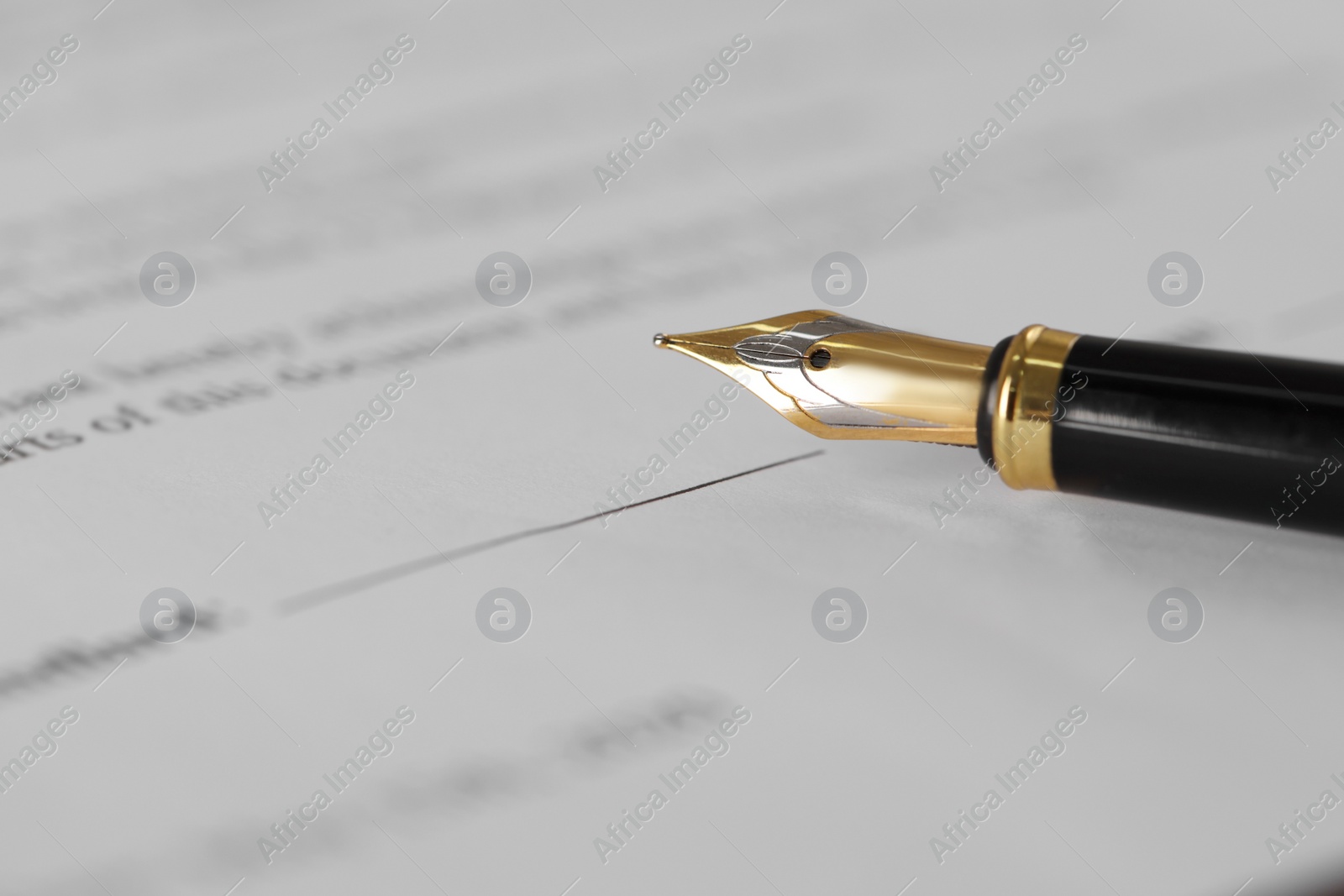 Photo of Fountain pen on document with place for signature, closeup and space for text. Notary contract