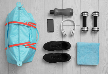 Flat lay composition with sports bag on wooden background