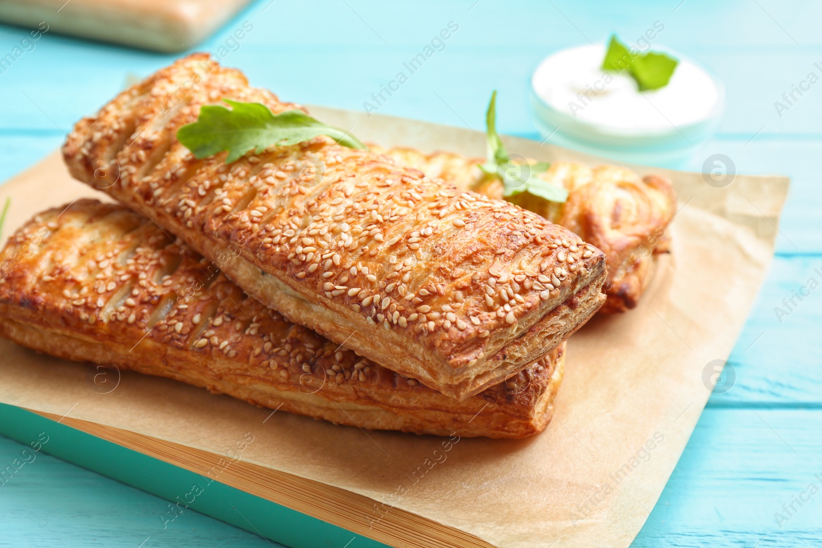 Photo of Fresh delicious puff pastry served on light blue wooden table