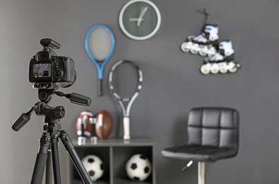 Photo of Workplace for blogger with camera and sportive equipment indoors