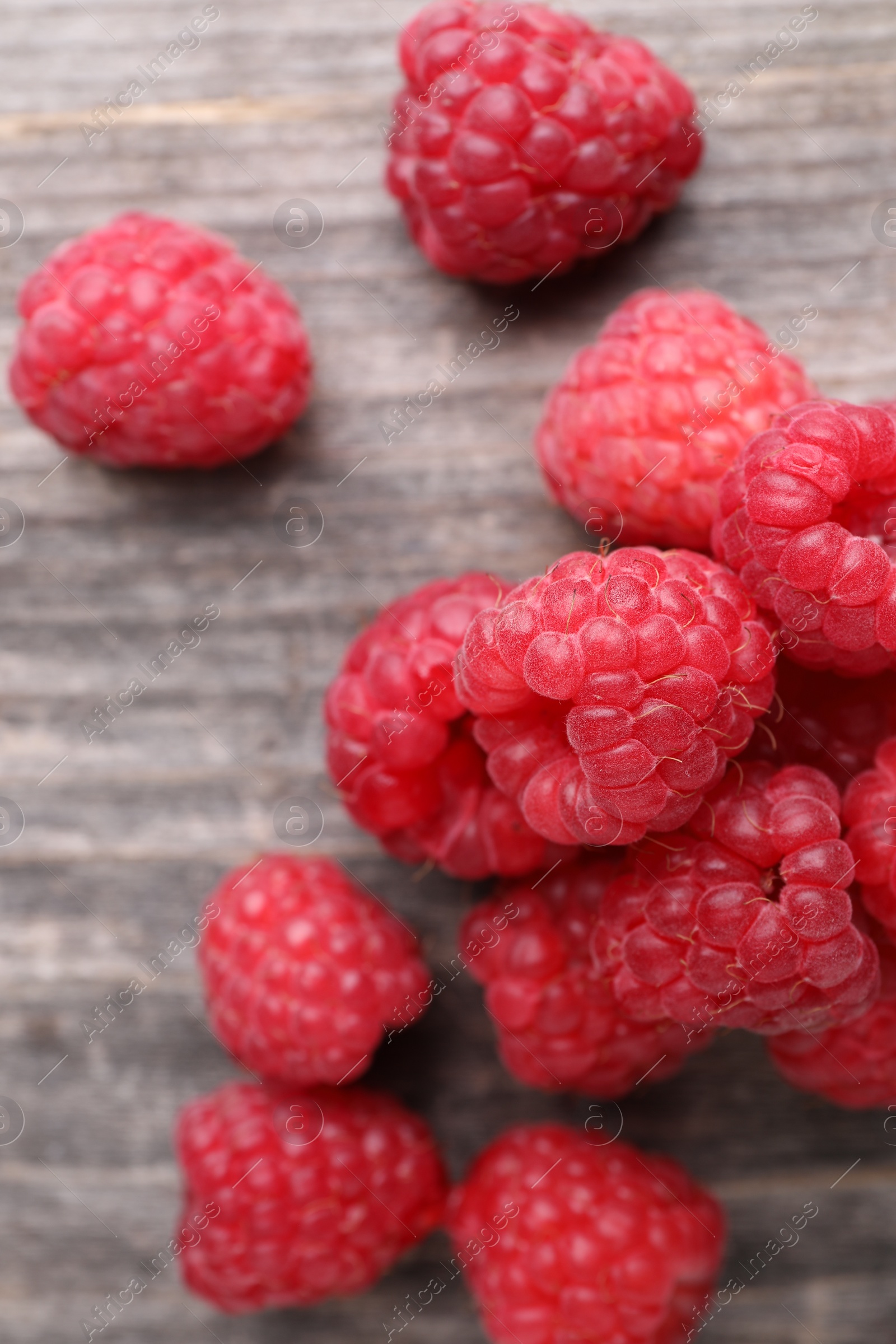 Photo of Tasty ripe raspberries on wooden table, top view