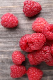 Photo of Tasty ripe raspberries on wooden table, top view