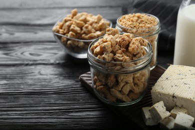 Photo of Different natural soy products on black wooden table, closeup. Space for text