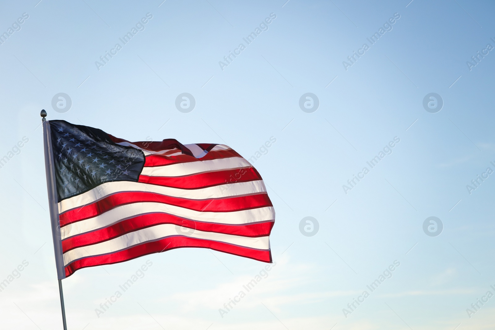 Photo of American flag fluttering outdoors on sunny day