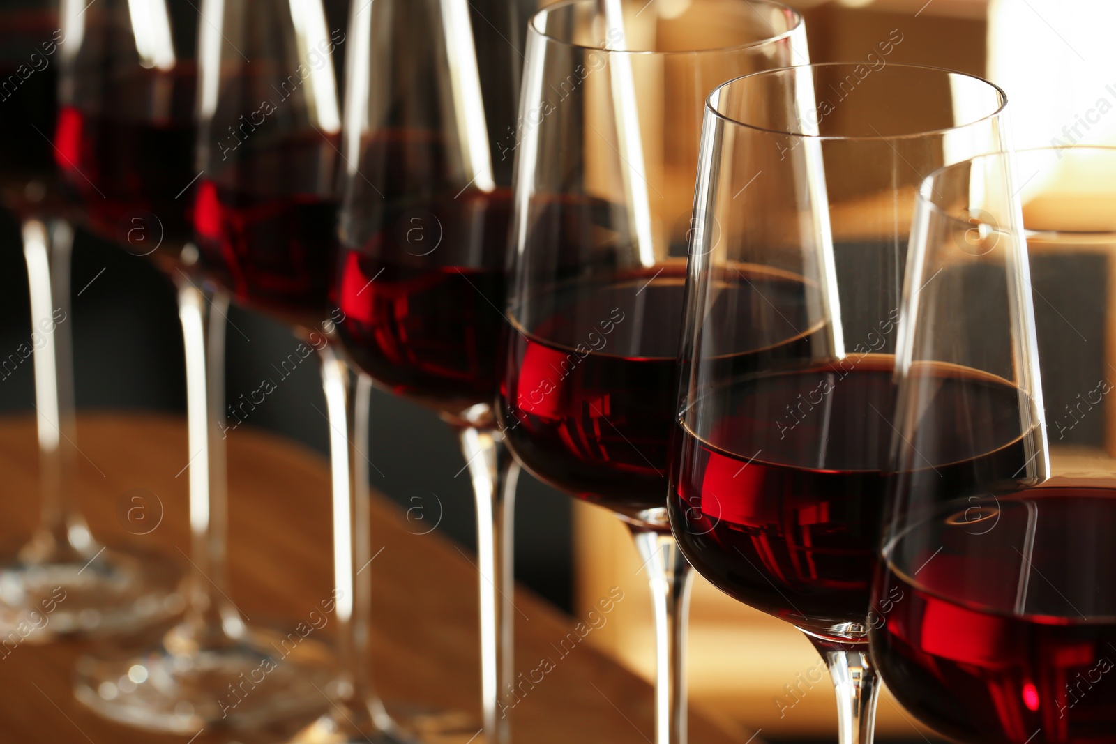 Photo of Glasses of red wine in cellar, closeup. Expensive drink