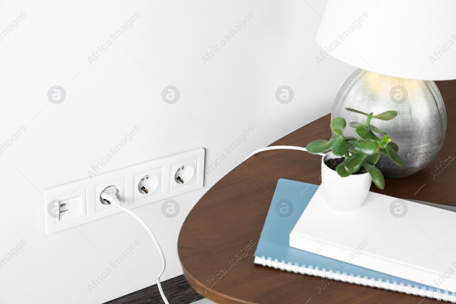 Photo of Electric power outlet sockets with charger on white wall