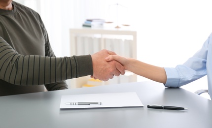 Photo of Lawyer shaking hands with client in office