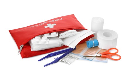 Photo of Red first aid kit with scissors, pins, cotton buds, pills, plastic forceps, medical plasters and elastic bandage isolated on white