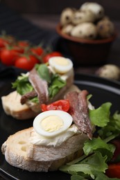 Photo of Delicious bruschettas with anchovies, cream cheese, arugula, eggs and tomatoes on table, closeup