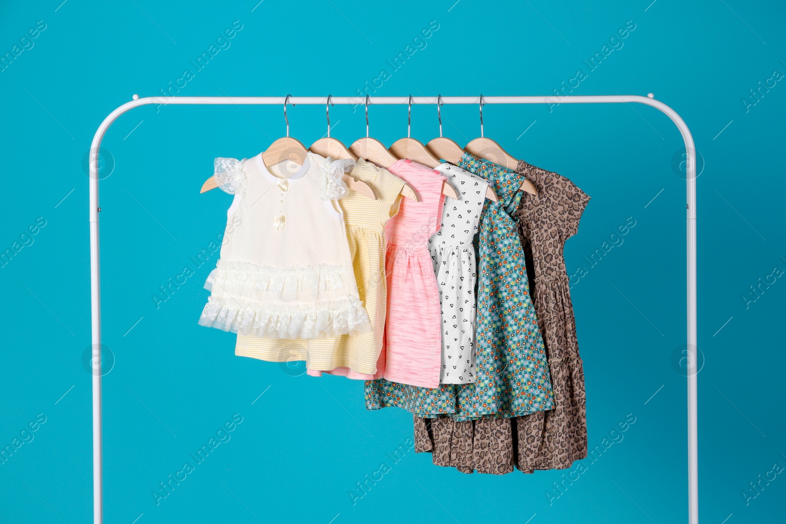 Photo of Rack with stylish child clothes on color background