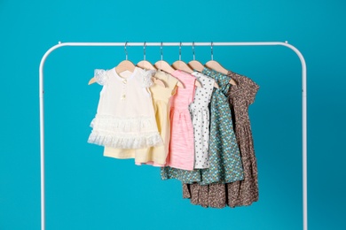 Photo of Rack with stylish child clothes on color background