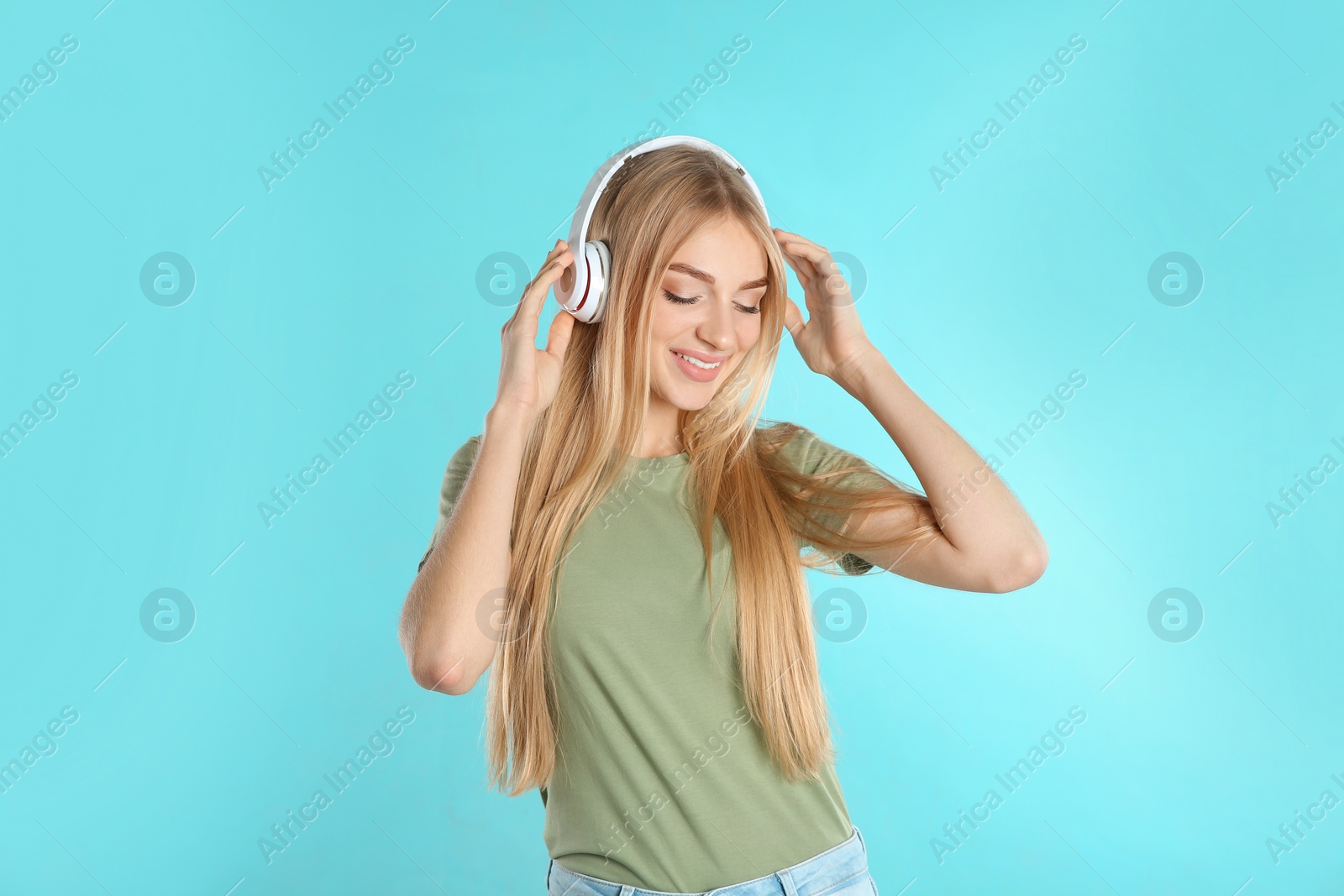 Photo of Beautiful young woman listening to music with headphones on color background