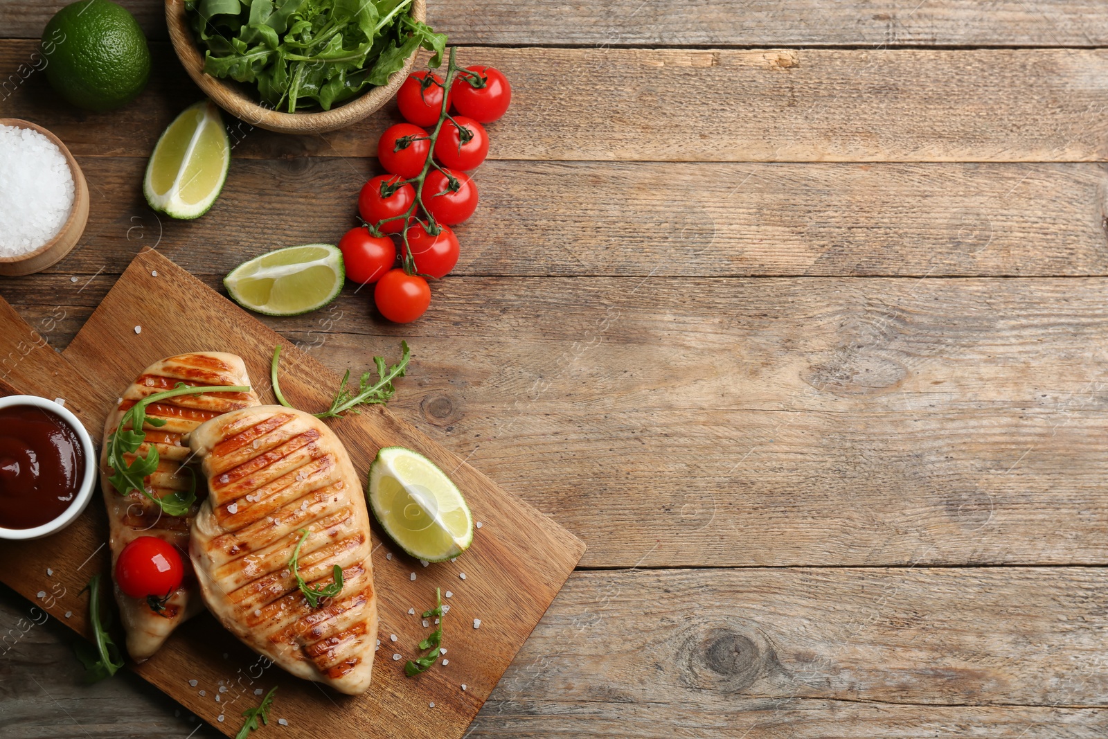 Photo of Flat lay composition tasty grilled chicken fillets on wooden table. Space for text