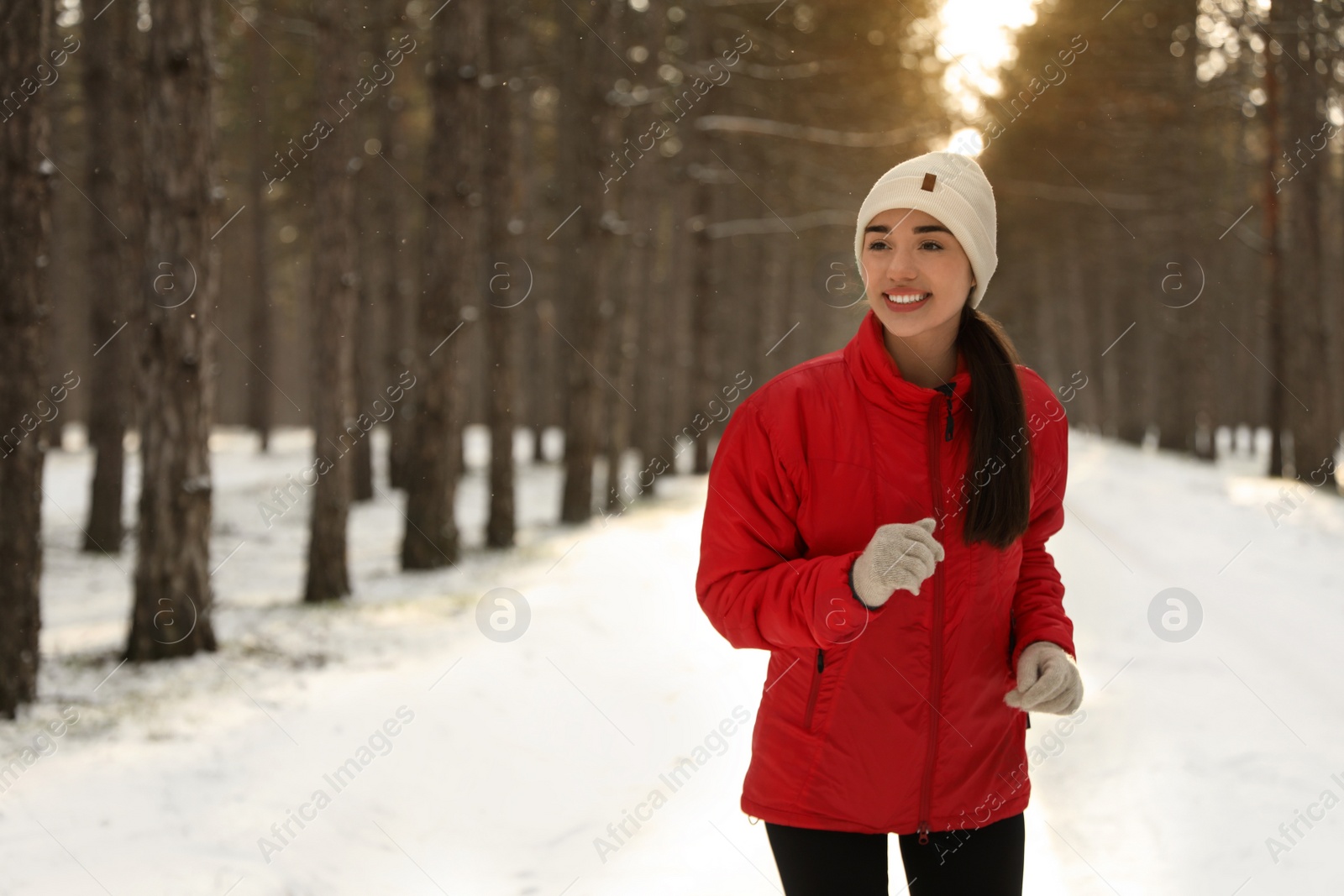 Photo of Happy woman running in winter forest. Outdoors sports exercises